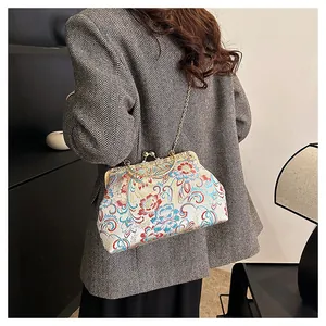 Detail view of a vintage Chinese style embroidered crossbody bag with gold chain strap