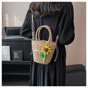 Detail of hand-woven straw bag featuring sunflower decor and secure drawstring closure