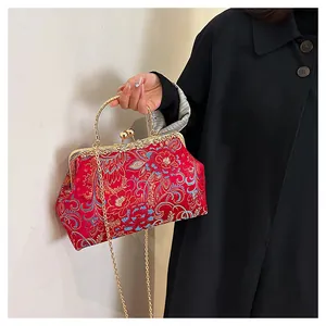 Detail of red floral embroidery on traditional Chinese handbag with golden metal handle