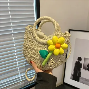 Detail of woven straw bag featuring 3D floral accents and drawstring lining closure