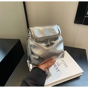 Dettaglio della mini borsa a secchiello argento con texture metallica e chiusura a sfere