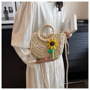 Detail of hand-woven straw bag featuring Goodday floral patch and a sunflower charm