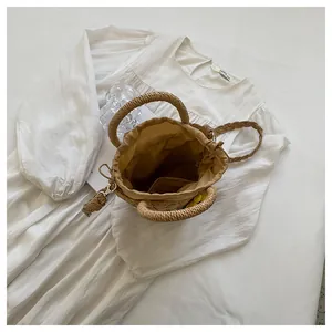 Detail of straw bucket bag featuring drawstring lining and woven shoulder strap