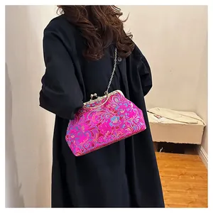 Detail of rose red Chinese embroidery handbag with intricate floral patterns and chain