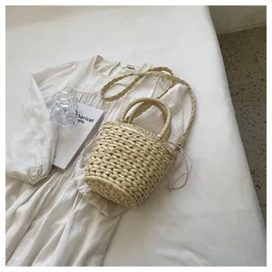 Detailed close-up of a woven straw bucket bag with drawstring closure and ring handle