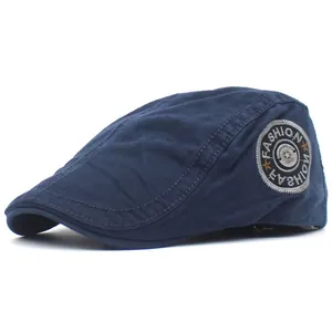 Detailed view of navy cotton flat cap showing retro embroidery badge and fine stitching