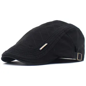 Détail de la casquette béret noire en coton avec motifs surpiqués et plaque logo métallique