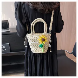 Detailed look at the straw bucket bag with sunflower decor and Goodday embroidery