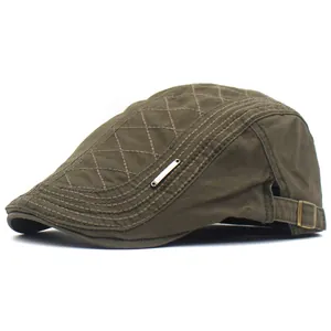 Détail de béret en coton vert armée avec surpiqûres en losange et boucle de réglage métal