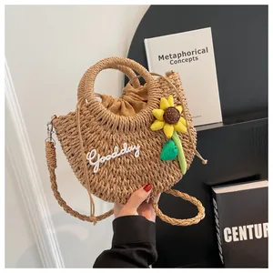 Detail of woven straw bag with Goodday embroidery, sunflower charm and drawstring liner