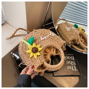 Close-up of woven straw bag with sunflower applique, 'good day' embroidery and drawstring
