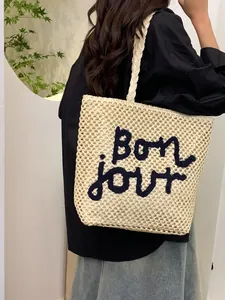 Hollow straw tote bag with Bon jour embroidery and braided handles for summer beach vacation