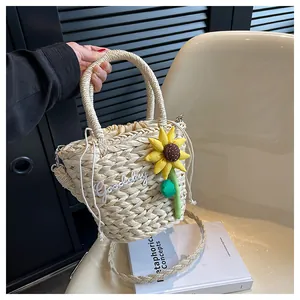Detail of beige straw bucket bag with sunflower decor and Goodday embroidery