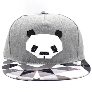Dettaglio del cappellino snapback grigio con patch panda geometrico e visiera a motivi
