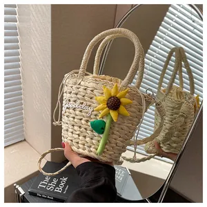 Detailed view of a straw bucket bag with sunflower decor and Good day embroidery
