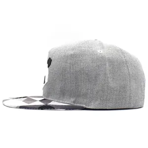 Dettaglio cappellino snapback grigio con visiera geometrica nera, bianca e grigia