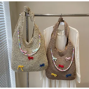 Detail of straw woven tote bags featuring colorful handmade bows and beaded ornaments