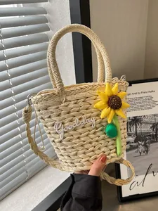 Woven straw bucket bag with sunflower decor and Goodday embroidery in warm natural light
