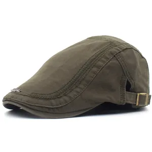 Detail of the olive green cotton flat cap featuring side stitching and metal logo