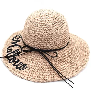 Detailed macro view of beige raffia sun hat featuring Mallorca embroidery and black ribbon
