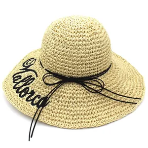 Detailed macro view of beige raffia sun hat featuring elegant Mallorca letter embroidery