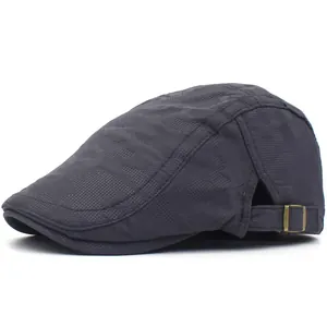 Detail of dark grey textured fabric with camouflage pattern and brass buckle on beret hat