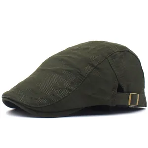 Close-up of olive green flat cap with bubble embossed texture and bronze metal buckle