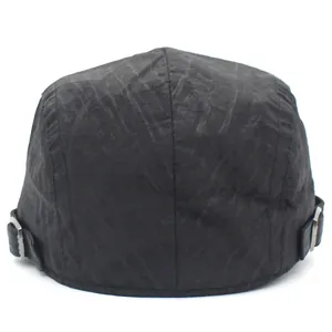 Detail of adjustable metal buckles and pleated texture on the back of the black beret
