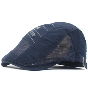 Détail du béret en maille bleu foncé avec broderie tendance et boucle en métal réglable