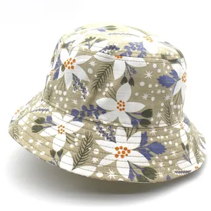 Detailed view of floral bucket hat featuring white flowers and navy leaves on khaki canvas