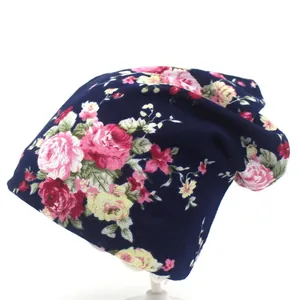 Gros plan détaillé d'un bonnet tricoté bleu foncé avec des motifs de roses roses