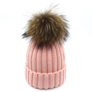 Nahaufnahme der rosa Strickmütze mit großem flauschigem Bommel und dicker Rippstruktur