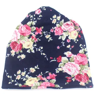 Détail du bonnet en maille bleu marine orné de motifs de roses colorées et de fleurs