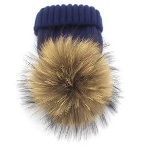 Dunkelblaue Grobstrickmütze mit großem flauschigem Waschbär-Pelzbommel für den Winter