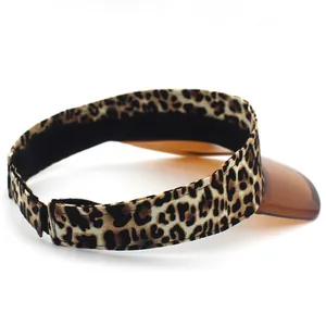 Detail view of leopard print sun visor with orange translucent brim and velcro strap