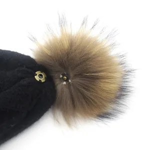 Women's cable knit beanie featuring a detachable real raccoon fur pom pom via metal snap