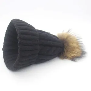 Women's black cable knit beanie with large brown raccoon fur pom-pom for winter warmth