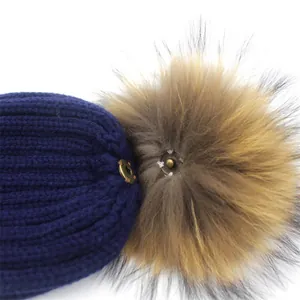 Blaue Strickmütze mit abnehmbarem Kunstfell-Bommel und Metalldruckknopf-Detail