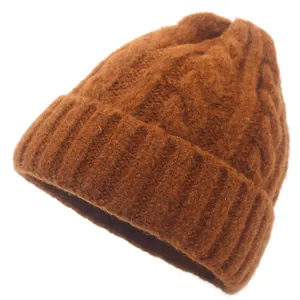 Close-up of caramel thick knit beanie featuring cable pattern and ribbed cuff texture