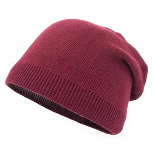 Close-up of the burgundy knitted beanie showing thick ribbed texture and warm fabric