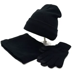Close-up of black winter knit set with touchscreen gloves, scarf, and beanie hat