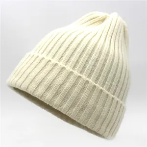 Detail of cream rib-knit wool beanie showing thick vertical stripe texture and cuffed brim