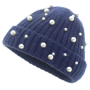 Détail de la texture en maille côtelée bleu marine et perles blanches sur le bonnet