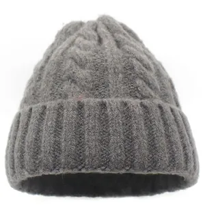 Thick grey cable knit beanie for winter featuring warm ribbed cuffs and twisted patterns