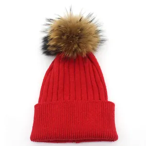 Red rabbit fur knit beanie with large faux raccoon pompom and striped texture