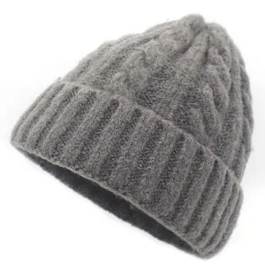 Dark grey chunky knit beanie with thick cable patterns and soft wool texture