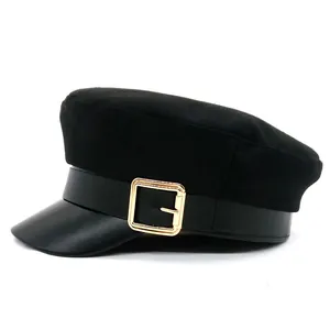 Detail of vintage black baker boy hat with wool body, PU leather brim and gold buckle