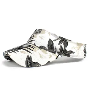 Detail of a white canvas sun visor with gray palm leaf prints and a black ROAD label tag