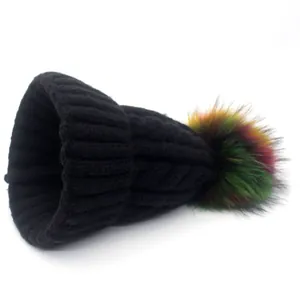 Thick black knitted winter beanie with colorful faux fur pom-pom for cozy warmth