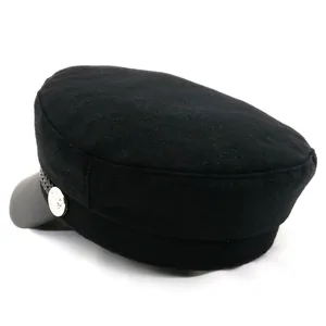Détail de la casquette de marin noire avec visière en cuir et bouton argenté latéral